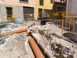 Ditch with new water pipes in the ground of a residential street. Public work concept.