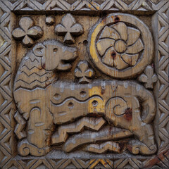 A detailed wooden carving of a mythical creature, featuring floral and geometric patterns.