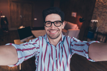 Photo of young man corporate worker beaming smile make selfie wear striped shirt modern office home...