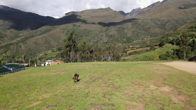 un joven y atractivo campesino montando un caballo caminando bajo la c&aacute;lida luz del sol durante el d&iacute;a. Concepto de viaje de estilo de vida saludable, turismo experiencial.rural,quechua,estilo de vida