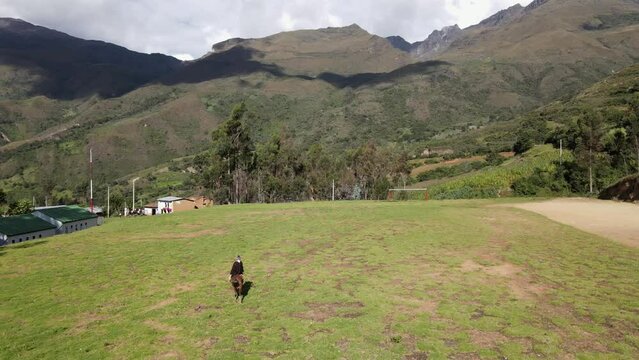 un joven y atractivo campesino montando un caballo caminando bajo la c&aacute;lida luz del sol durante el d&iacute;a. Concepto de viaje de estilo de vida saludable, turismo experiencial.rural,quechua,estilo de vida