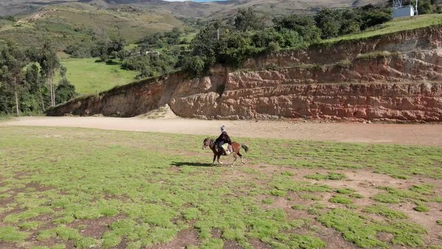 un joven y atractivo campesino montando un caballo caminando bajo la c&aacute;lida luz del sol durante el d&iacute;a. Concepto de viaje de estilo de vida saludable, turismo experiencial.rural,quechua,estilo de vida