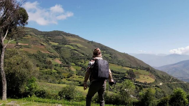 Hermosas monta&ntilde;as y hombre joven turista caminando con mochila en el camino en verano. Paisaje con turista en la cima de la monta&ntilde;a, bosque, colinas, cielo blancos con nubes, Viaje,quechua,sierra