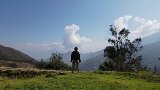 Mujer excursionista viajera caminando, aventurera con mochila sinti&eacute;ndose victoriosa frente a la monta&ntilde;a, al aire libre para la educaci&oacute;n de la naturaleza en vacaciones. Concepto de viaje,salto
