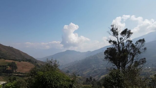 Mujer excursionista viajera, aventurera con mochila sinti&eacute;ndose victoriosa frente a la monta&ntilde;a, al aire libre para la educaci&oacute;n de la naturaleza en vacaciones. Concepto de viaje,casa quechua
