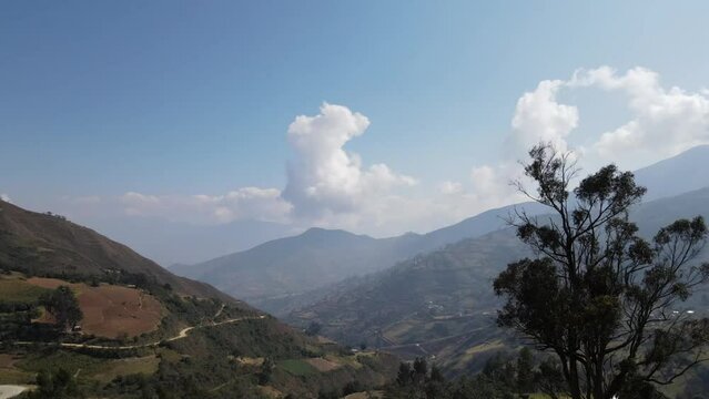 Mujer excursionista viajera, aventurera con mochila sinti&eacute;ndose victoriosa frente a la monta&ntilde;a, al aire libre para la educaci&oacute;n de la naturaleza en vacaciones. Concepto de viaje,casa quechua