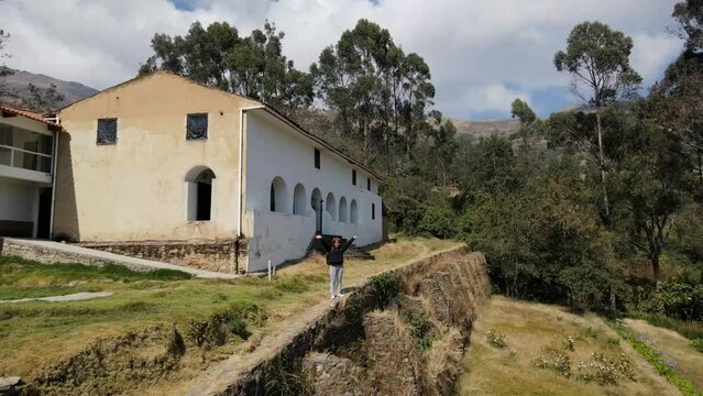 Mujer excursionista viajera, aventurera con mochila sinti&eacute;ndose victoriosa frente a la monta&ntilde;a, al aire libre para la educaci&oacute;n de la naturaleza en vacaciones. Concepto de viaje,casa quechua