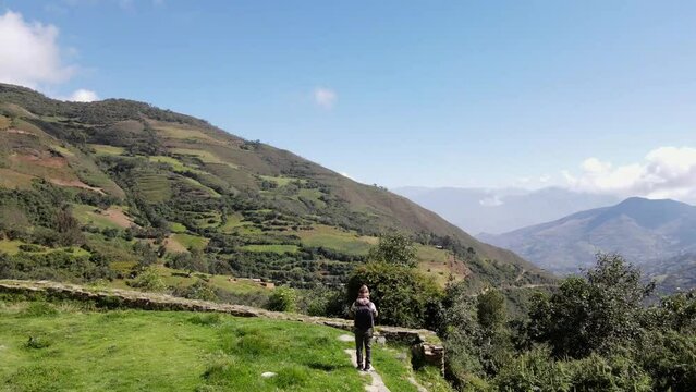 Hermosas monta&ntilde;as y hombre joven turista caminando con mochila en el camino en verano. Paisaje con turista en la cima de la monta&ntilde;a, bosque, colinas, cielo blancos con nubes, Viaje,quechua,sierra