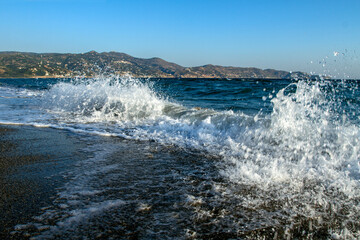 Beach Greece on a sunny day, with sandy beach and blue sea. Sandy's sea beach. Holidays in Greece. Summer vacation. Relaxation concept. Greece island Crete. Euro travel.