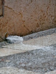 Wasser strömt aus Wasserrohr auf Straße bei Starkregen