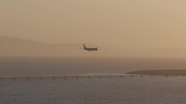 Aerial view of a plane landing at San Leandro Airport at sunset, USA