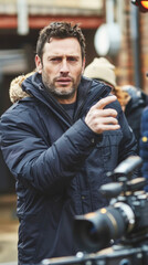 Fototapeta premium A man standing confidently in front of a camera, likely recording a video or taking a photograph