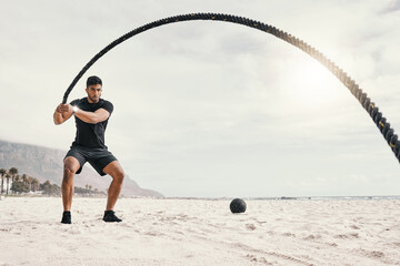 Fitness, man and battle rope on beach for endurance challenge, strength or core training in...