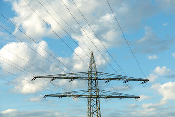 electric pylon at corn field with cloudy sky in scenic afternoon light