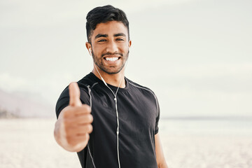 Happy, man and fitness with thumbs up and earphones for listening to music on run or beach workout....