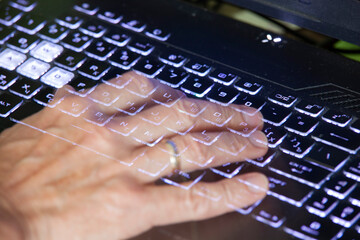 Close-up view of men's hands typing on a laptop. Relevance. Working from home, writer creating an article, browsing the internet using modern wireless technology. Transparent hands like a ghost's.