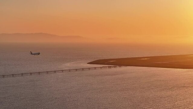 Aerial view of a plane landing at San Leandro Airport at sunset, USA