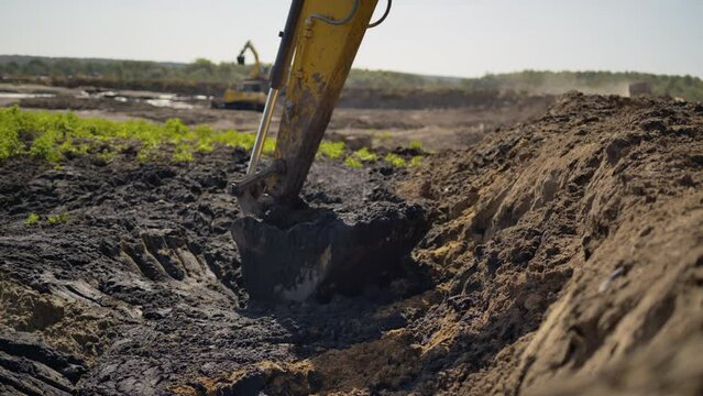 Modern excavation equipment digs into sludge removing for further treatment. Operation of heavy machinery in water treatment facilities