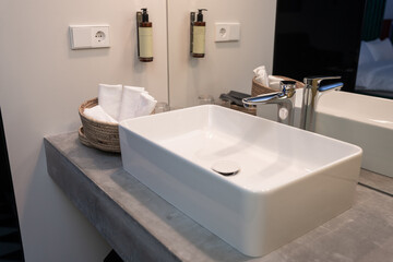 Hotel sink and towels in a straw basket, service industry concept