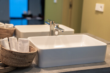 Hotel sink and towels in a straw basket, service industry concept