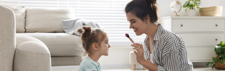 Mother and her little daughter doing makeup at home, banner design