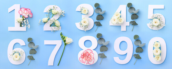 Numbers and beautiful flowers on light blue background, top view. Banner design