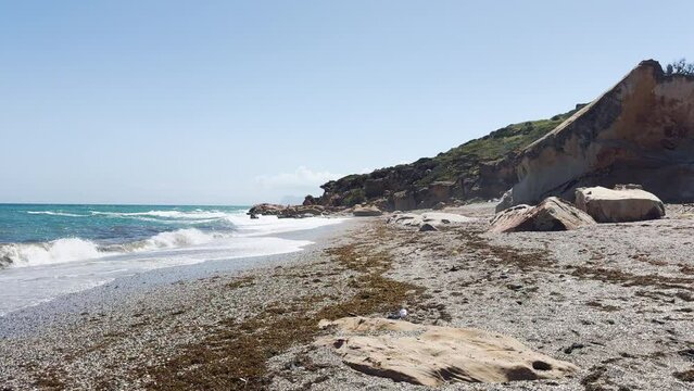 Wide-angle view of a scenic beach with a prominent rocky outcrop, blue sea, and clear sky. costa del sol, sotogrande, andalusia. playa de sardina