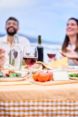 Vertical table foreground. Blurred happy two young adult friends enjoying lunch together outdoors....