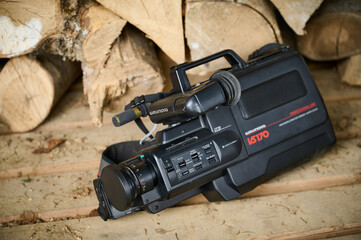 Ukraine 11.04.2024. Grundig vhs170. Old vhs video camera near wooden logs and garbage. close-up....