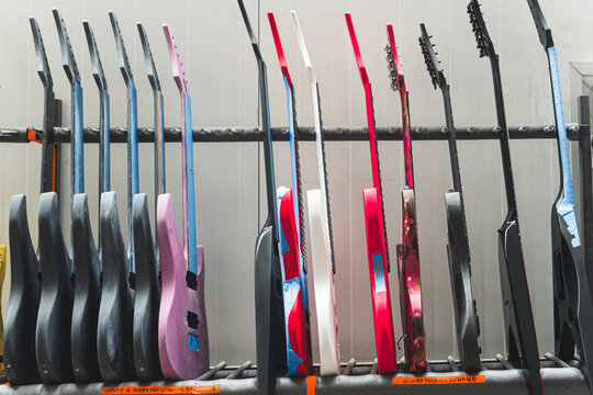 side view of different types and colors of guitars at the workshop, guitar workshop and factory. High quality photo
