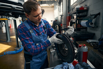 Young man determines wear of vehicle disc