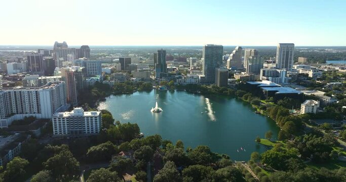Orlando city in Florida with waterfront office and condo buildings and Lake Eola Park recreational area. Development of housing in USA.