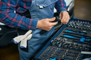 Professional mechanic choose instruments for repair in tire fitting