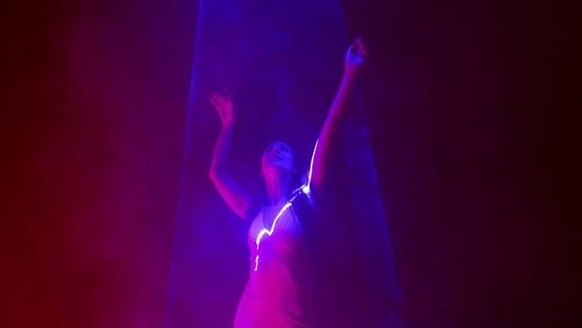 Classy woman in dress, violet laser illumination light, neon. Model dancing