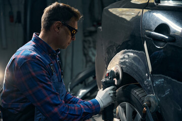 Skilled man working with front fender in tire fitting
