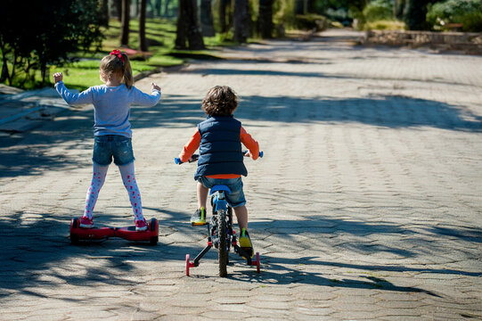 Menino e menina brincando, andando de patins e bicicleta se divertindo com a fam&iacute;lia