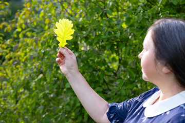 mature woman holding oak green leaf, active lifestyle for health, rejuvenating power nature,...