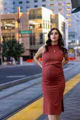 Portrait of a pregnant woman in a red dress in a maternity shoot in Downtown Phoenix, Arizona.