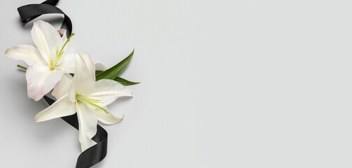 Black funeral ribbon and lily flowers on white background with space for text