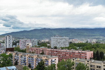 clouds over the residential area of Tbilisi with mountains on a background