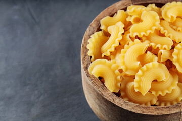 Uncooked Creste di Gallo Pasta on Dark Concrete Background, Copy Space