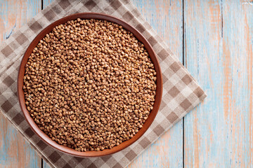 Buckwheat Grains in Bowl on Wooden Background, Top View, Copy Space