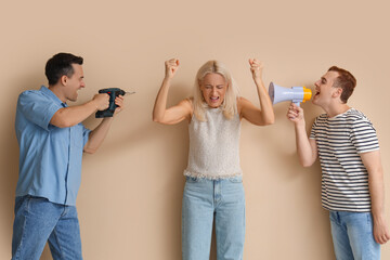 Mature woman suffering from loud neighbours on beige background