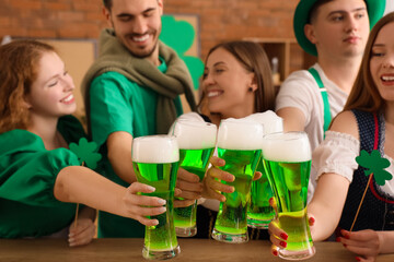 Group of young friends with beer celebrating St. Patrick's Day in pub, closeup