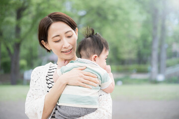 A mother holding her baby in a fresh green park Happiness, happiness, and maternal images of...