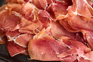 Sliced ​​ham is laid out on a plate close up