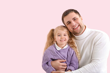 Happy father and his cute little daughter on pink background
