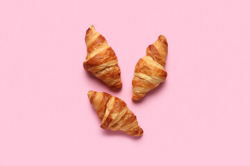 Tasty croissants on pink background