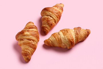 Tasty croissants on pink background