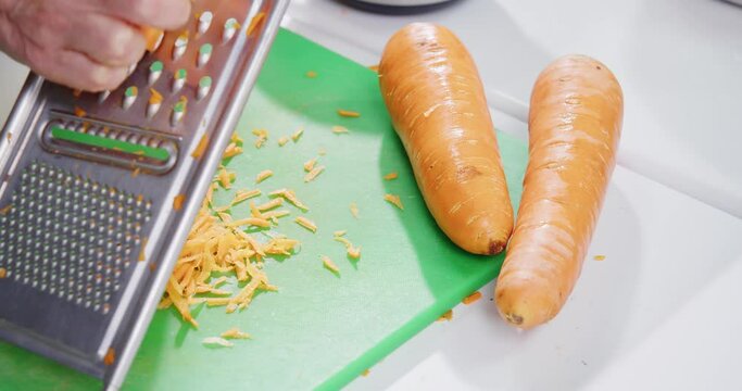 Close up shot of hands grating carrot